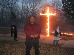 Rallying: Klans members that wish to remain anonymous stand around a burning cross at one of their rallies. 
