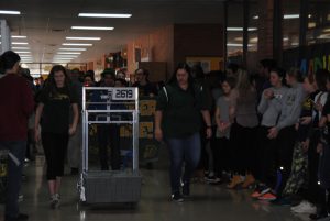 As The Charge and the DHS band marches the hall, students clap along to the school fight song. This was prior to the competition, as the team was celebrated for making it to states. The students traveled to Grand Rapids to compete April 14-16. Photo by Reece Leydorf